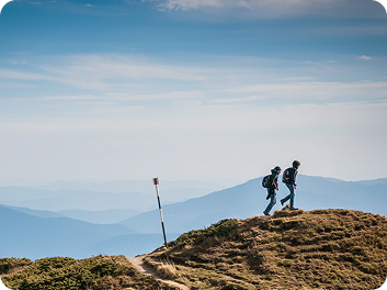 Two hikers walking on a mountain ridge